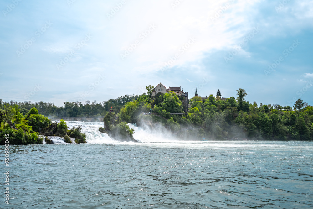 Tourists experiencing the impressive waterfalls below Laufen Castle at the Rhine Falls from the rocks and tourboats. Rhine Falls, Neuhausen am Rheinfall, Schaffhausen, Switzerland.