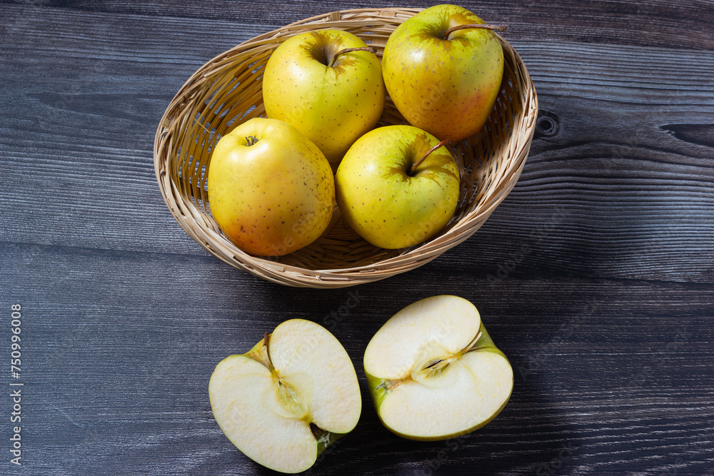 Succulent sweet yellow apples, golden variety on a woody background.