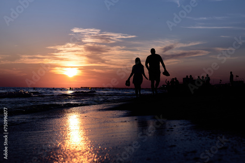 Serene Silhouette: A Couples Beach Stroll at Sunset