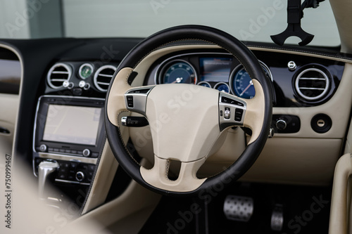 Modern Luxury Car Interior, Leather Steering wheel, Cream and Black Trim © Harry