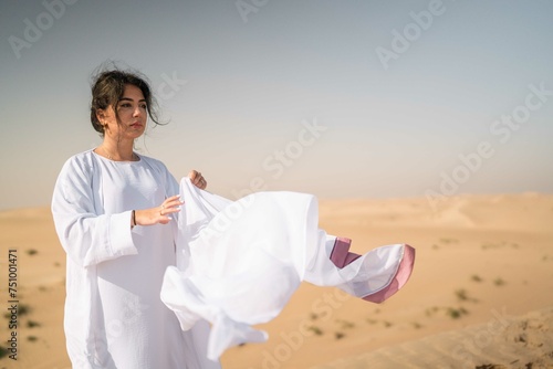 Arabic woman wearing white abaya in the desert