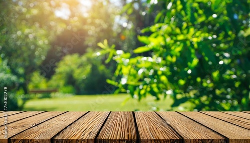 nature themed background with a wooden table in a garden featuring bokeh in a spring summer setting the wood surface is versatile serving as a shelf counter desk and for picnic meals and produc