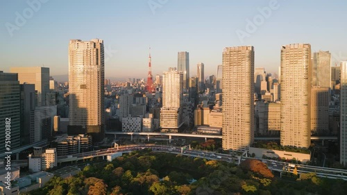 tokyo city downtown aerial view drone flying over park in the fall,modern buildings skyline at dawn,traffic on big highway street