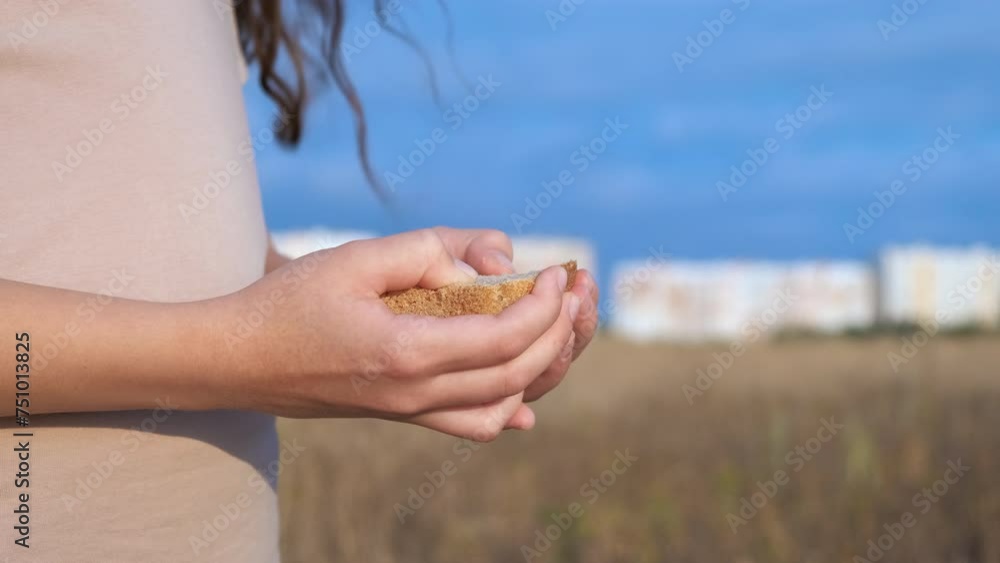 Keep protect a bread. A hungry child with her hands protect a bread outdoor. Keep protect a bread. A hungry child with her hands protect a bread outdoor.