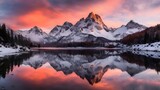 Panorama of snowcapped mountains reflecting in a lake at sunset