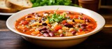 A bowl filled with delicious Italian Minestrone soup, featuring a colorful mix of beans, carrots, and fresh parsley. The rich broth simmers with savory flavors, creating a hearty and comforting meal.