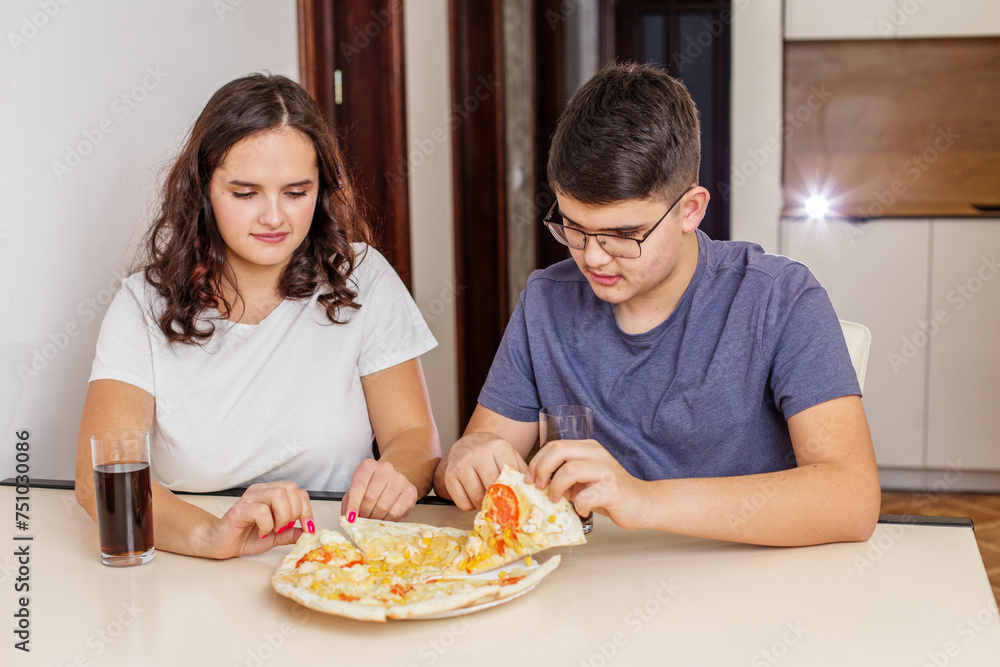 Teenagers Enjoying Pizza and Soda at Home