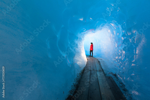 woman standing in beautiful blue ice cave photo