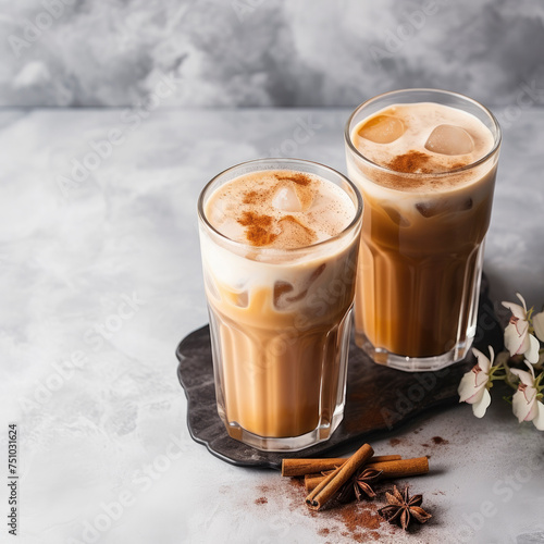 Masala tea with milk and cinnamon in tall glass glasses on marble background,top view, close up