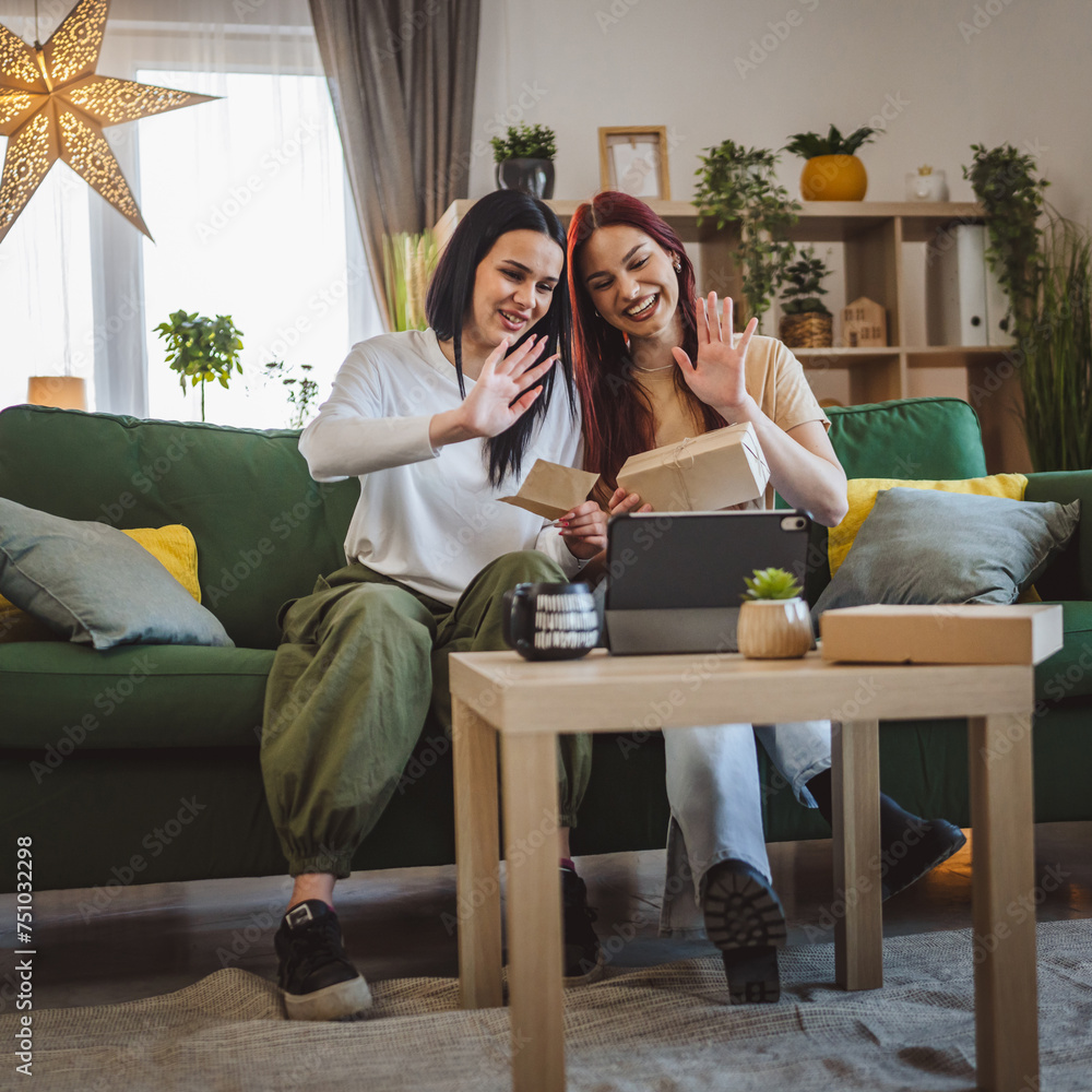 two women sisters or friends open presents in front of digital tablet two women sisters or friends open presents in front of digital tablet