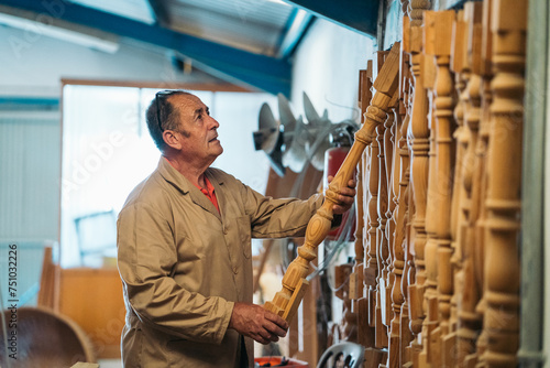 Joiner with wooden baluster in workshop