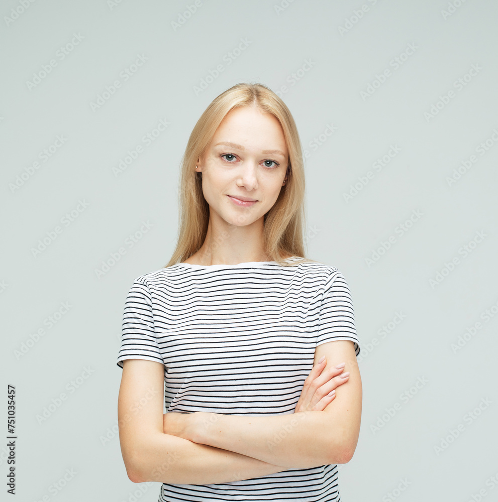 Obraz premium young woman with long blond hair dressed casual posing with crossed arms over grey background