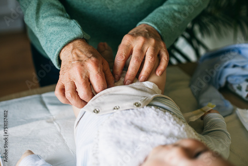 Old woman changing diaper for newborn baby  photo