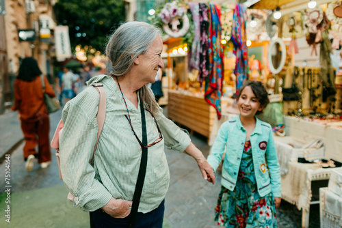 Grandmother and granddaughter having fun in street market  photo