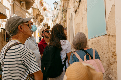 Group of tourists looking at a map in an old Italian City.  photo