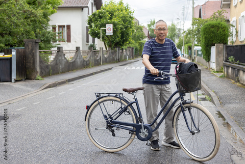 full body portrait of senior retired asian man with bicycle on street