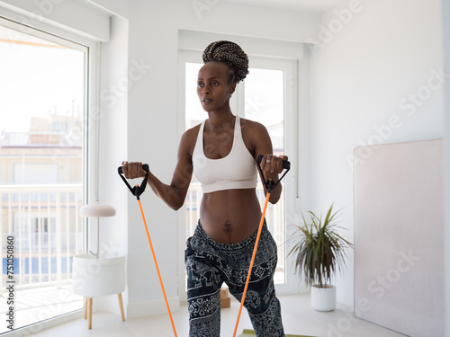 Fit black woman in expectancy training with band photo