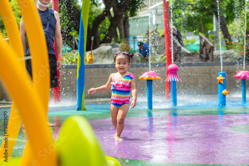 Adorable little girl enjoying in colorful city child water park outdoor activity