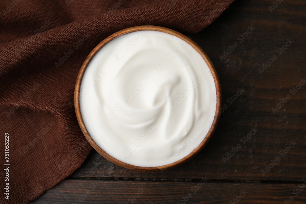 Delicious natural yogurt in bowl on wooden table, top view Delicious natural yogurt in bowl on wooden table, top view