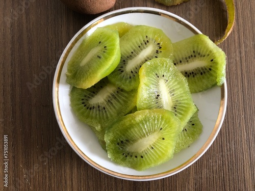 
Fresh kiwi sliced on plate on a wooden background with copy space
​ photo