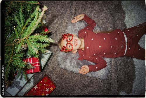 Playful child under Christmas tree, ugs photo