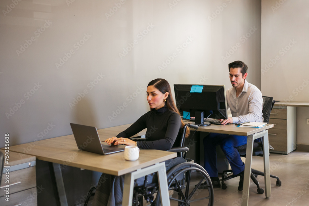 Disabled woman in a wheelchair working in an office Disabled woman in a wheelchair working in an office