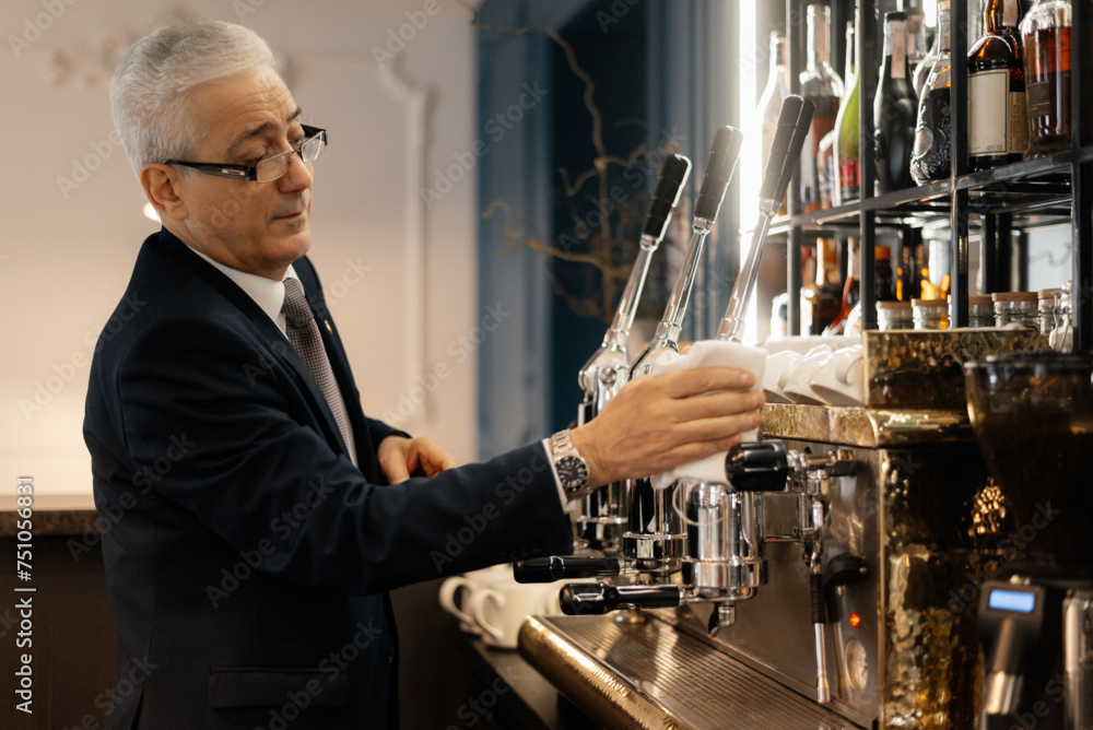 Mature Professional bartender prepares coffee machine
Mature Professional bartender prepares coffee machine