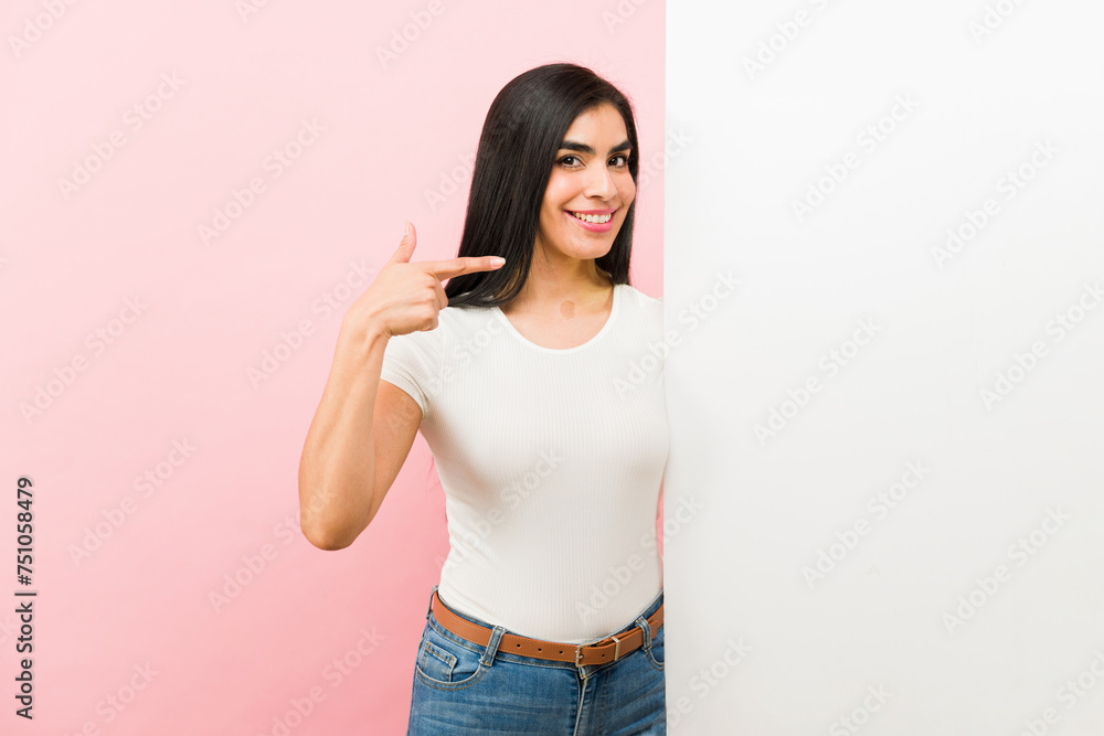 Attractive latin woman pointing to a white copy space Attractive latin woman pointing to a white copy space
