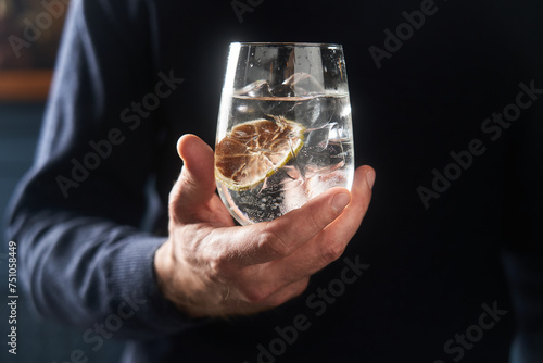 hand with glass of cold beverage with ice photo