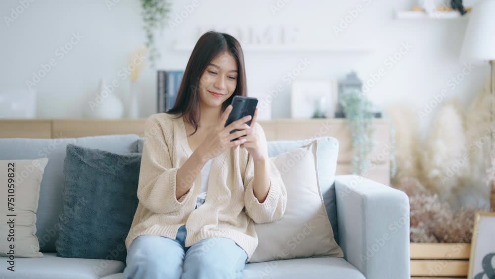 Happy young asian woman relax on comfortable couch at home, typing chat message on smartphone, smiling girl use cell phone chatting, searching information on browser wireless internet, online shopping Happy young asian woman relax on comfortable couch at home, typing chat message on smartphone, smiling girl use cell phone chatting, searching information on browser wireless internet, online shopping