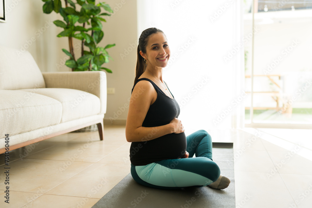 Cheerful pregnant woman working out in the living room