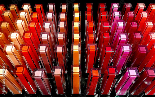 Many bottles with lipsticks in different colors. A group of containers in gradient shades