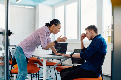 A furious business director of a startup office berating her employee for business mistakes and errors