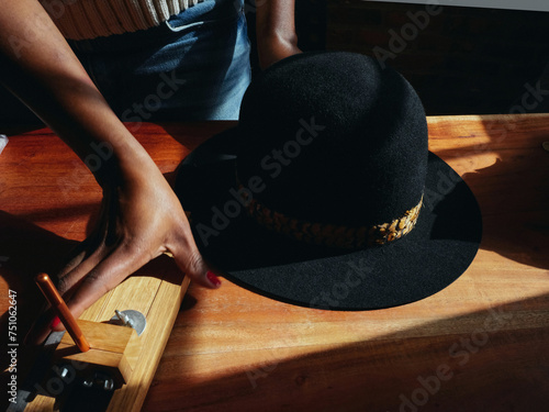  Close-up of hands and hat. woman hat maker in a workshop space.  photo