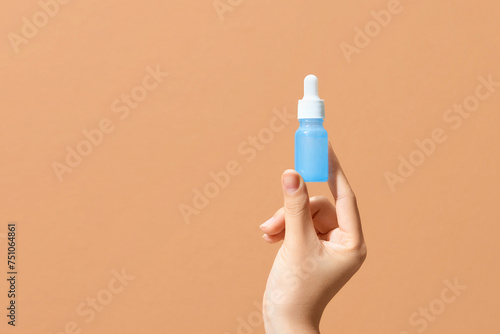 Hand holding a medical glass dropper bottle