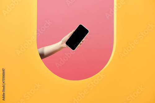 Woman's hand presenting modern smartphone with blank screen photo