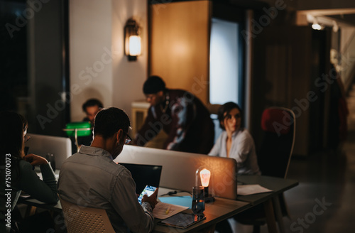 A diverse team of multigenerational business colleagues engages in a collaborative meeting in a modern office setting  illuminated by soft lighting.