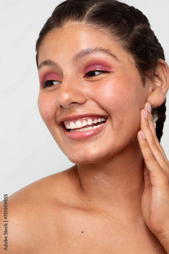 Teenager with braided hair smiles while touching her face Teenager with braided hair smiles while touching her face