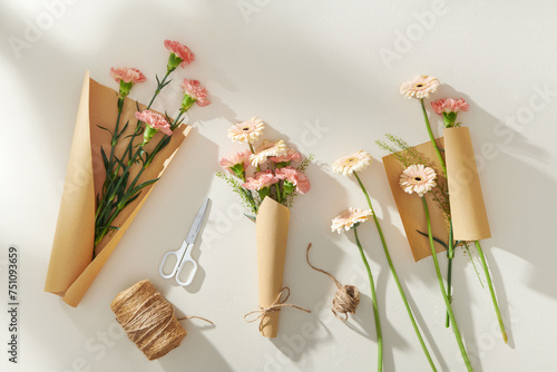Beautiful spring flowers in wrapping paper, scissors and rope