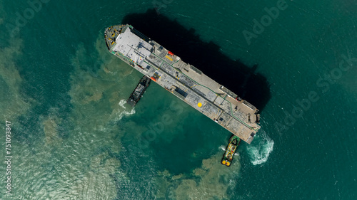 Aerial top view Tugboat pushing dragging Large RoRo (Roll on Roll off) in sea. © SHUTTER DIN