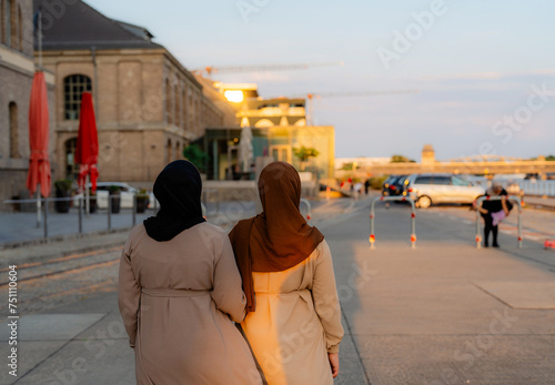 Rear view of two unrecognisable women in hijab walking in the city  photo