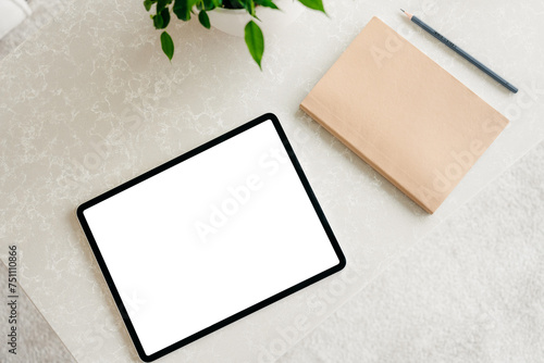 A tablet with a white screen is on the table photo