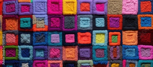 A handmade woolen blanket featuring a variety of colorful crocheted squares  creating a vibrant and visually striking pattern. Each square is intricately stitched together to form a cozy and unique