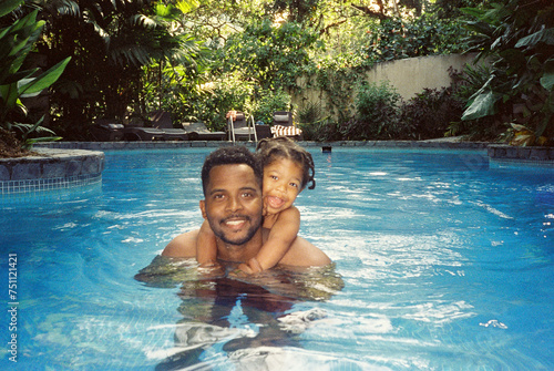 A father with his toddler swimming in the pool photo