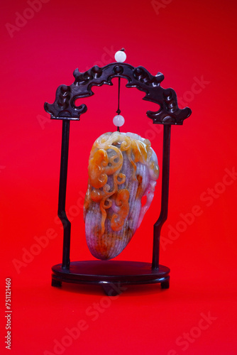 Beautiful Jadeite Jade sculpture with Chinese auspicious animals on peanut isolated on red background