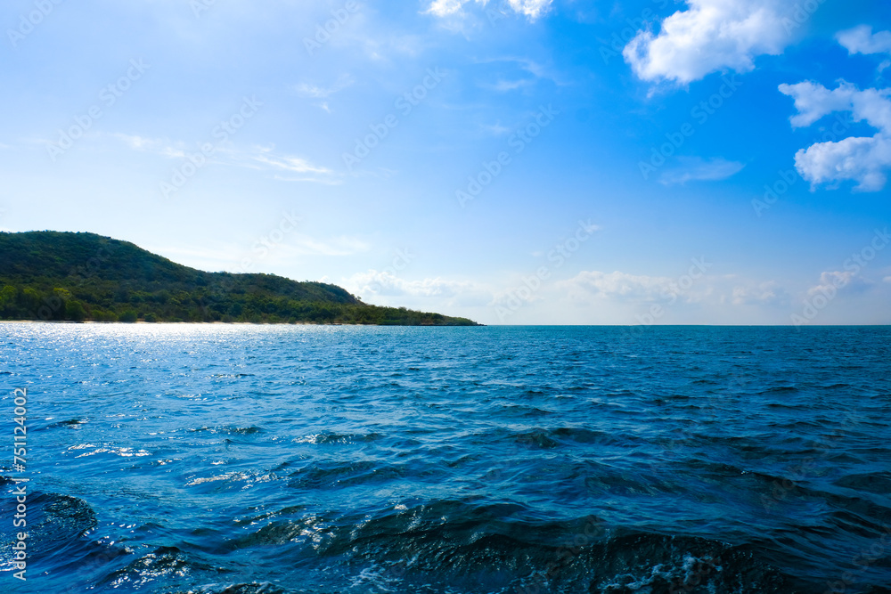 background for summer vacation concept. Nature of the beach and sea, summer with sunlight, sandy beach The sparkling sea water contrasts with the blue sky	