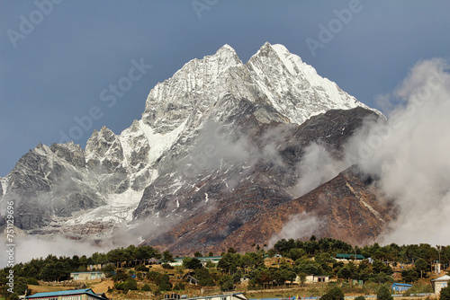 Thamserku twin peaks at 6608 meters shine bright in the morning sun, presenting a magnificent view as it towers above the sherpa market town of Namche Bazaar in the high Himalayas of Khumbu, Nepal photo