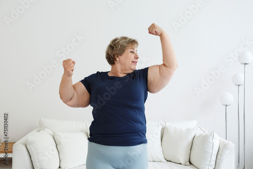 Happy plus size woman showing biceps