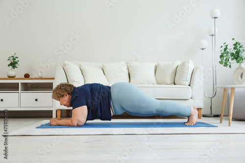 Plus size woman doing forearm plank at home