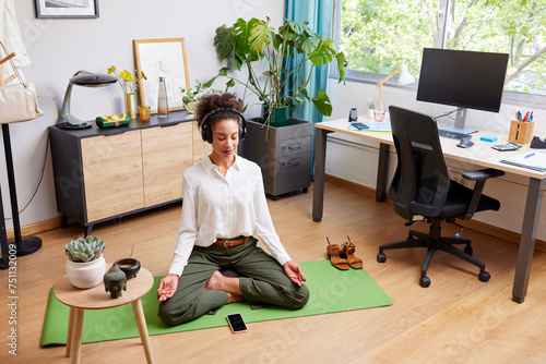 Woman meditating in Lotus pose after remote work photo